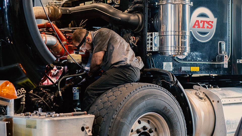 Diesel-mechanic-working-on-semi-engine
